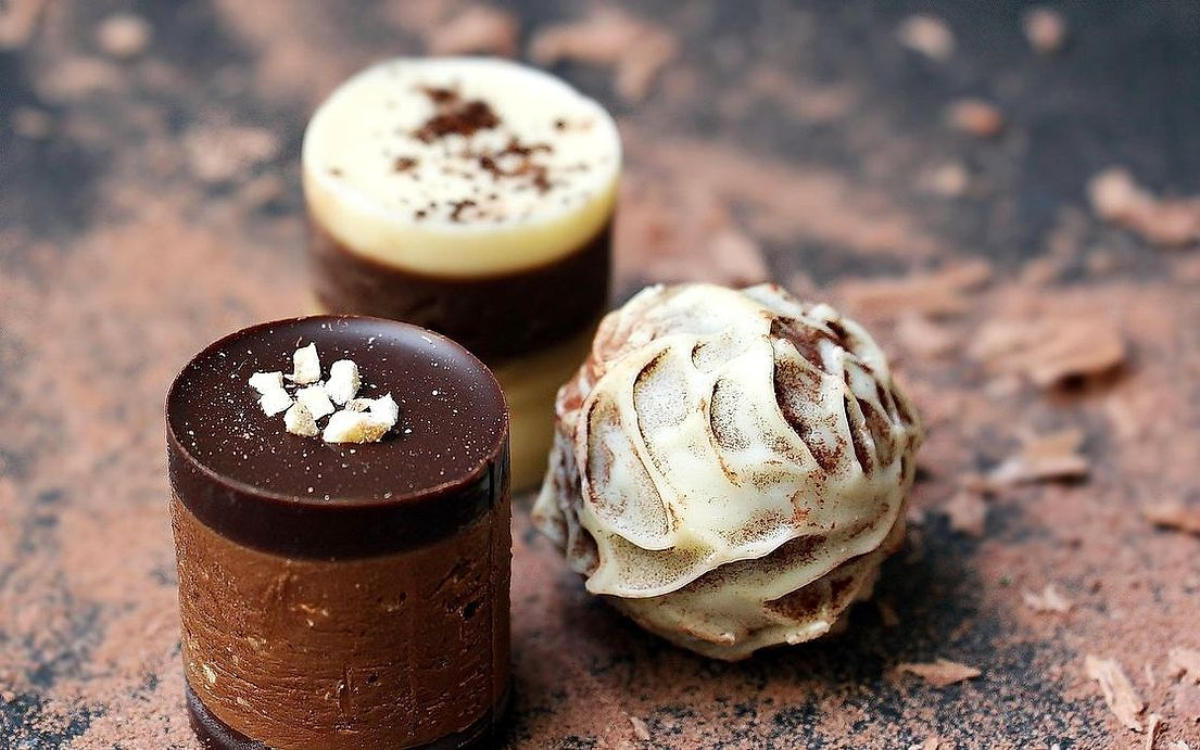 Artisan chocolate desserts displayed on a rustic wooden board
